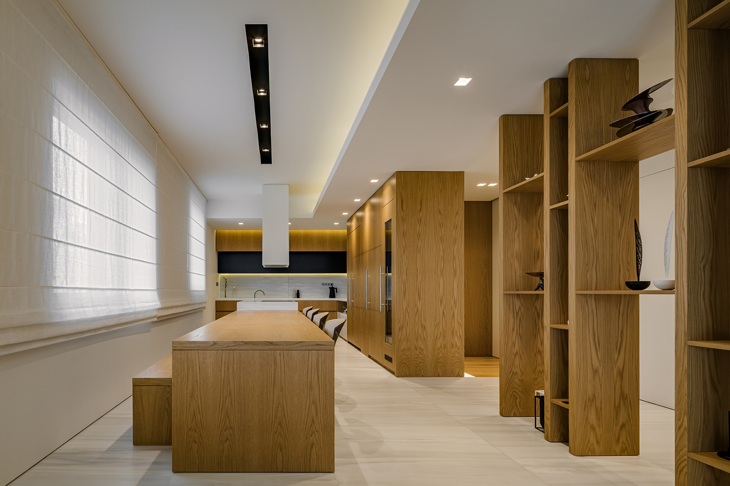 Dining room and high kitchen cupboards in continuation of a lining, with fitted electrical appliances and wine cooler.